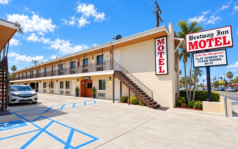 The motel seen from the street, with the office entrance and the roadside sign.